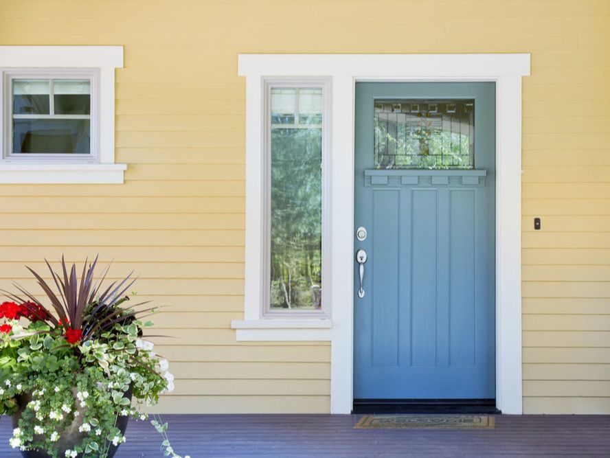 front of yellow house with blue door